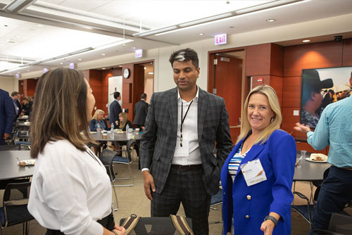 A panelist smiles while answering follow-up questions from two audience members after the Scams, Security and Information Sharing panel during the 2024 Chicago Payments Symposium.