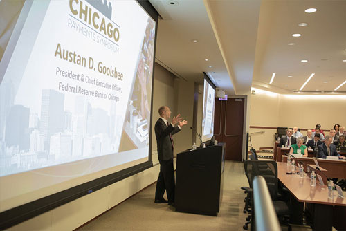 Keynote speaker Austan Goolsbee, president of the Federal Reserve Bank of Chicago, stands in front of a podium while introducing the 2024 Chicago Payments Symposium.